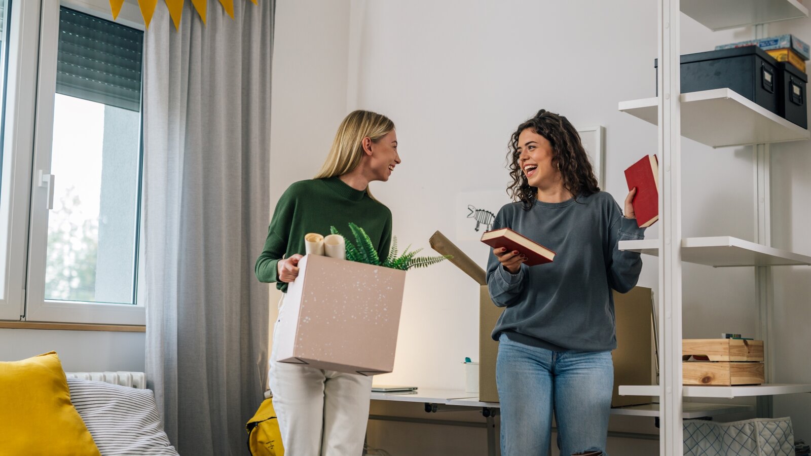 Zwei Frauen stehen in einer kleinen Studentenwohnung