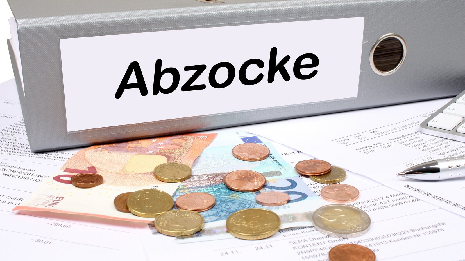 Auf einem Ordner steht das Wort "Abzocke". Davor liegen Euromünzen und Geldscheine.